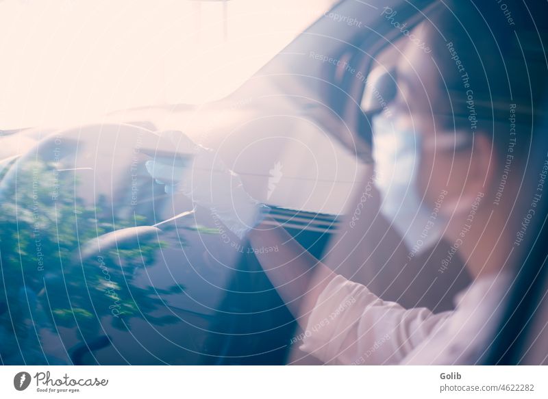 Woman in surgical face mask and gloves driving car woman reflection glass coronavirus pandemic go out buy essential items food medicine medication preventing