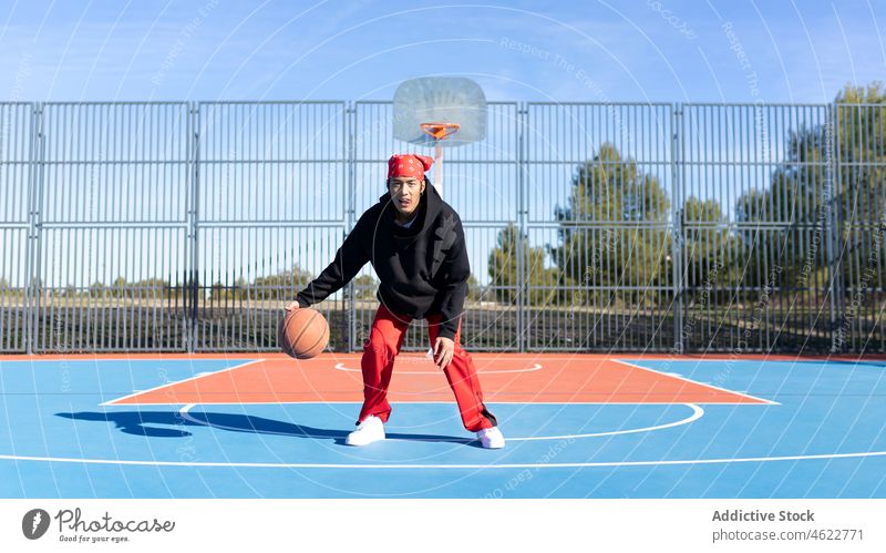 Asian man dribbling basketball ball on playground trick skill portrait sports ground game dribble hobby training asian fence male activity player sportsman