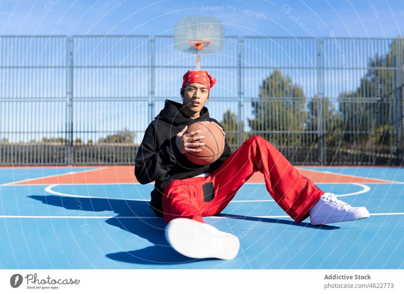 Asian man with basketball on playground sports ground game hobby training player asian fence male activity sportsman sportswear court confident serious guy