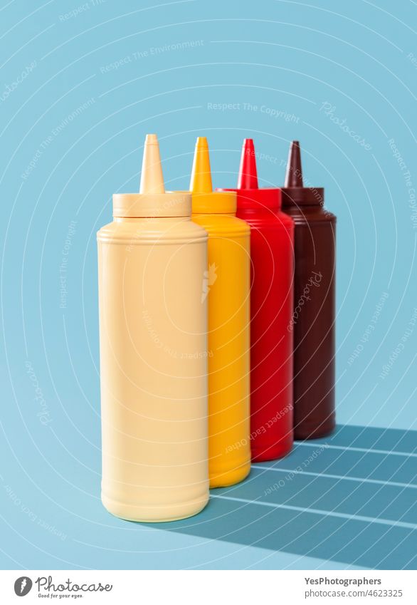 Sauce bottles aligned on a blue table. Variety of sauces. assortment background barbeque bbq blank brown burger catsup color condiment container copy space