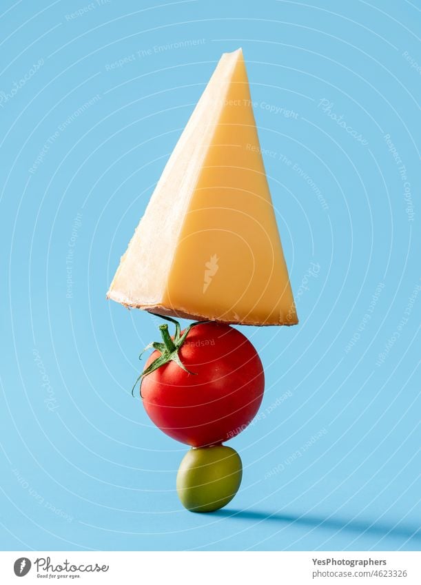 Swiss cheese with tomato and green olive isolated on blue background. balance breakfast close-up color cuisine cut cut out dairy diet dinner equilibrium food