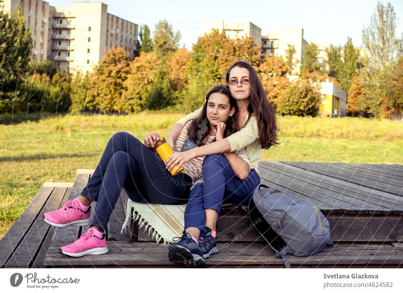 Two brunette girls happy family mom and daughter spend time resting together in the autumn park having fun, smiling, hugging Mental health Relax on nature