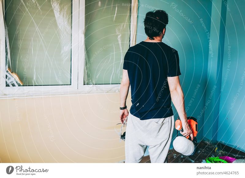 Young man doing a renovation at his home reform work job house paint room male working home improvement move removal relocation hard work work at home leisure