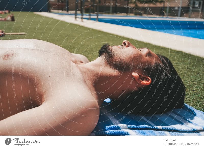 Young man in a pool with restrictions of social distance covid pandemic covid-19 male holidays summer summertime swimming pool contagious risk protection