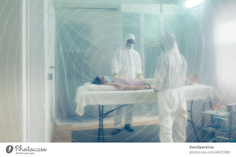 Doctors in a field hospital with a deceased person on a gurney covid-19 woman unrecognizable coronavirus doctor medical protective mask isolation stretcher