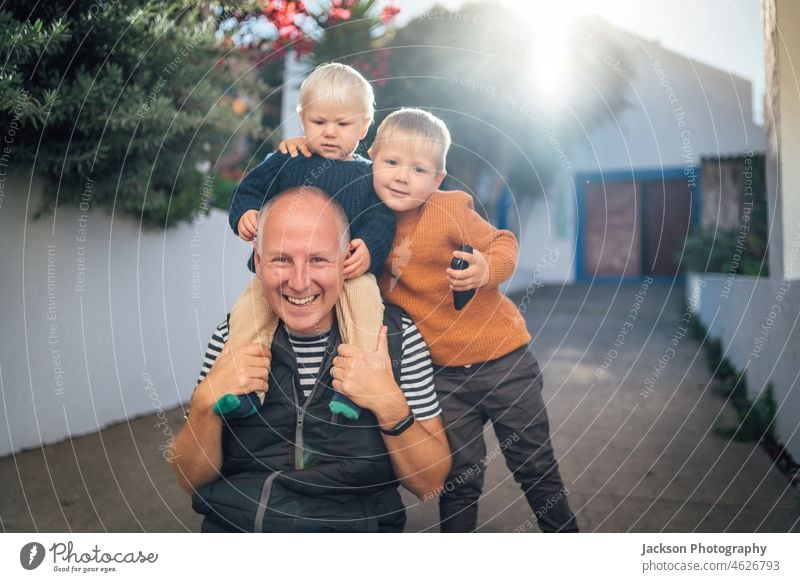 Father with his two sons hugging each other outdoor father family love autumn fall toddler baby brothers playful vacation kids small offspring children joy