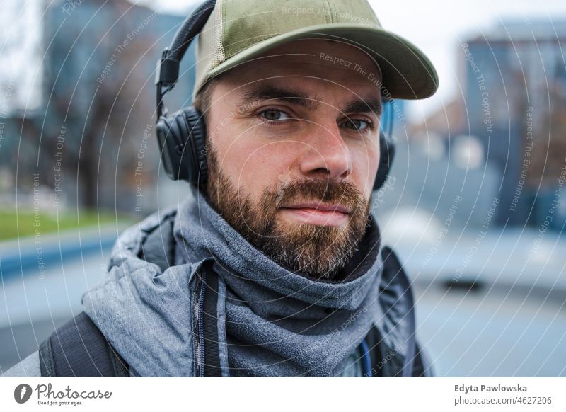 Portrait of young man with headphones listening music outdoors people cold weather autumn sportsman strength motivation determination one person bodybuilding