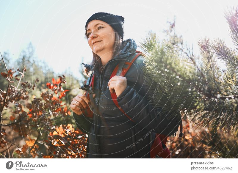 Woman enjoying hike on sunny vacation day. Female with backpack walking through forest trip hiking adventure travel summer journey wanderlust hiker exploring