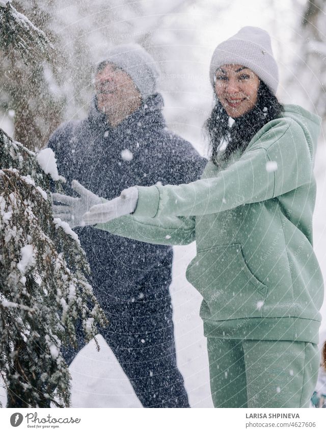 Happy couple playing winter game in forest outdoors. Love and leisure concept. woman active adult ball beautiful brunette caucasian cheerful clothes clothing