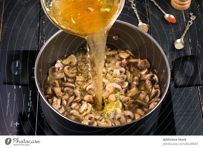 Broth pouring into pan with mushrooms soup broth stove cook pot kitchen culinary homemade cuisine prepare process cooker appliance tasty domestic delicious