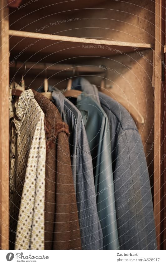Old work clothes in a locker made of wood garments Workwear Locker Wood Wooden locker Cupboard Shirt Jacket hangers clothes rail Forget forsake sb./sth. Hanger