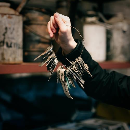 Old keychain with many keys on wire in hand bunch of keys Key Wire Hand Key power complete Access Workshop Storeroom Close Unlock Safety Lock Metal door Open