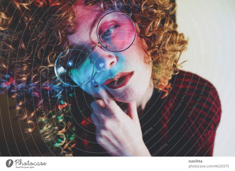 Young woman portrait illuminated by psychedelic lights retro neon party curly hair night pub alone lonely face proyector artistic creative neon lights