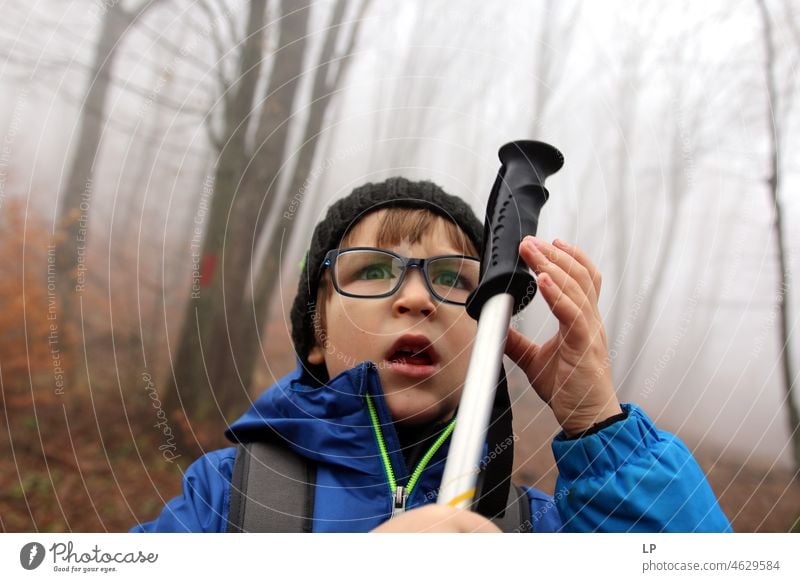 face of a beautiful child, wearing glasses,looking  in anger and holding a stick Stress Frustration Fear of the future Bans Grimace communication problem