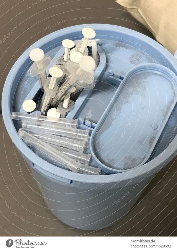 Covid-19 vaccination: blue plastic hygiene waste container with used syringes. / Photo: Alexander Hauk Immunization Syringe Inject inoculate sb. vaccinate sb.