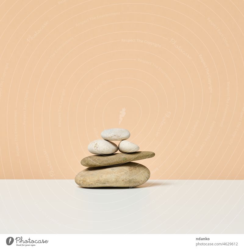 stack of round stones on a beige background. Scene for demonstration of cosmetic products, advertising backdrop blank brown creative design display empty indoor