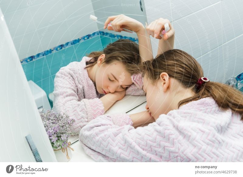 sleeping teen girl with a toothbrush in hands sleepy early morning tooth-brush tooth brush tired weary hold slumber fingers back lying stand shelf evening clean