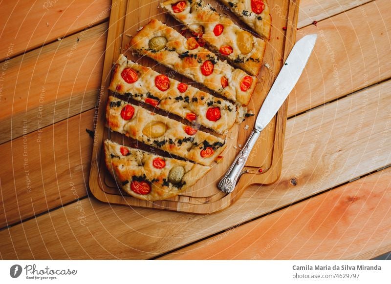 Homemade Italian Focaccia, with tomato and olive oil on a rustic wooden background. appetizer bake baked bakery black background bread cherry tomatoes closeup