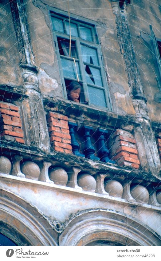 Child on Hainan China Taoism Window Haikou Occupants Building for demolition Chinese Grief Exterior shot Island Arm Poverty historical building Baroque Portugal