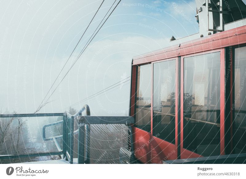 Red cable car in the snowy mountains Cable car Winter Mountain Clouds cloudy Blue Sky Snow Transport Trip holiday Winter vacation Moody