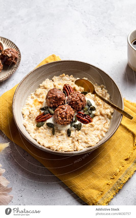 Bowl of cereals with nut chocolate balls and pumpkin seeds oatmeal morning pecan serve breakfast healthy milk porridge crunch portion delicious sweet bowl yummy