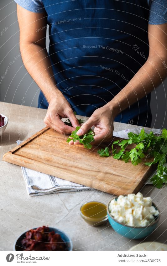 Faceless man preparing parsley at table herb greenery cook culinary cuisine recipe ingredient kitchen prepare chef food product gastronomy home process