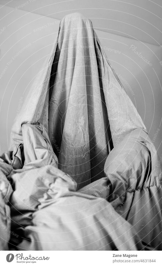 Person dressed as ghost in bed sheet, concept of dreams and fears, enjoying mundane tasks housework funny home halloween happy Black & white photo bed sheets