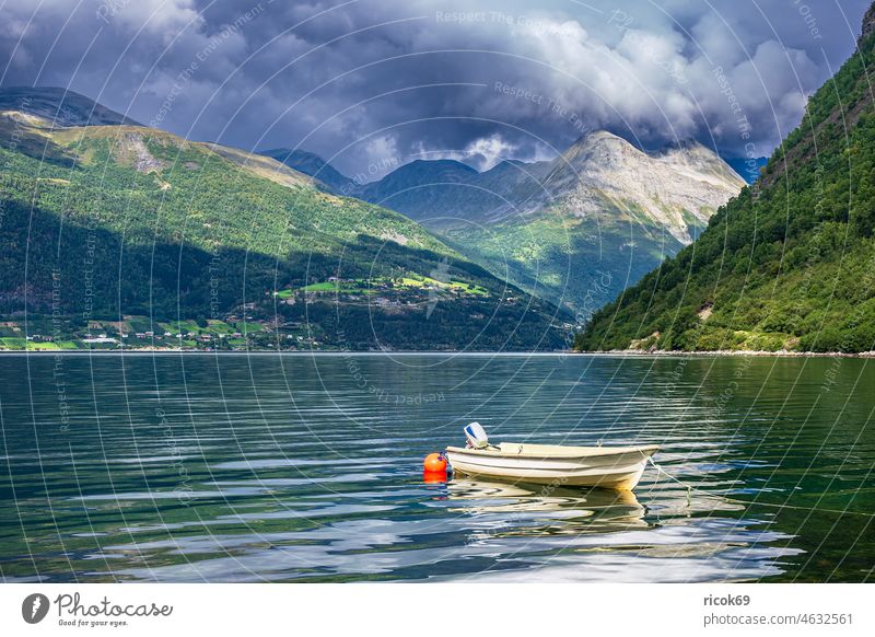 A boat on the Storfjord in Norway Fjord North Dal Scandinavia mountain mountains Landscape Nature Water Summer Sunnmore More og Romsdal Clouds Sky Blue Green