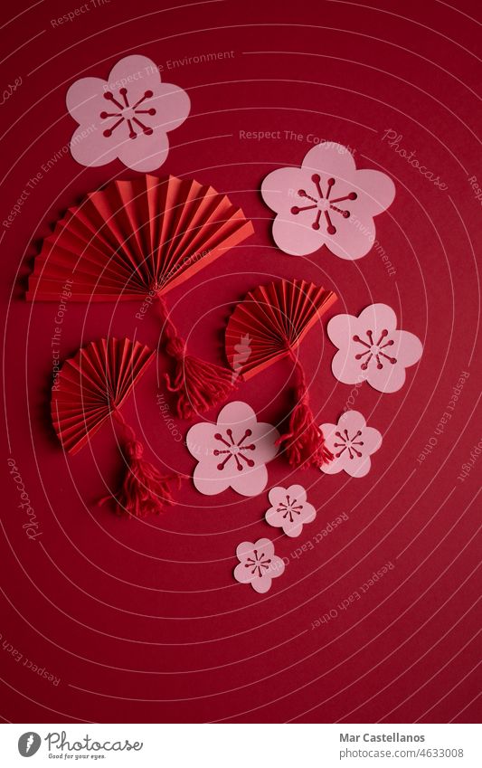 Chinese New Year. Decoration with traditional Chinese New Year motifs, cut out paper decorations on red cardboard background. Copy space. Vertical photo. China