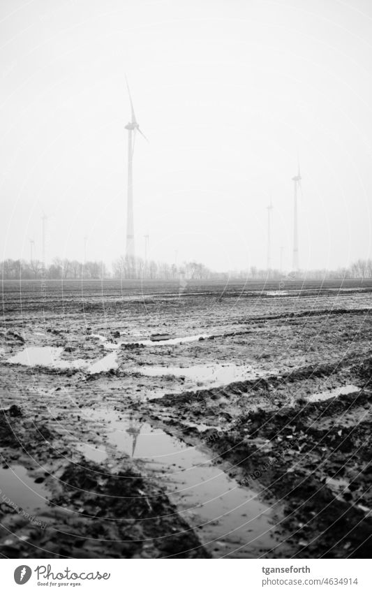 Mud puddle and pinwheels slush slobbery acre tractor tracks Water Puddle Wet windmills wind turbine Dirty Rain Exterior shot Reflection