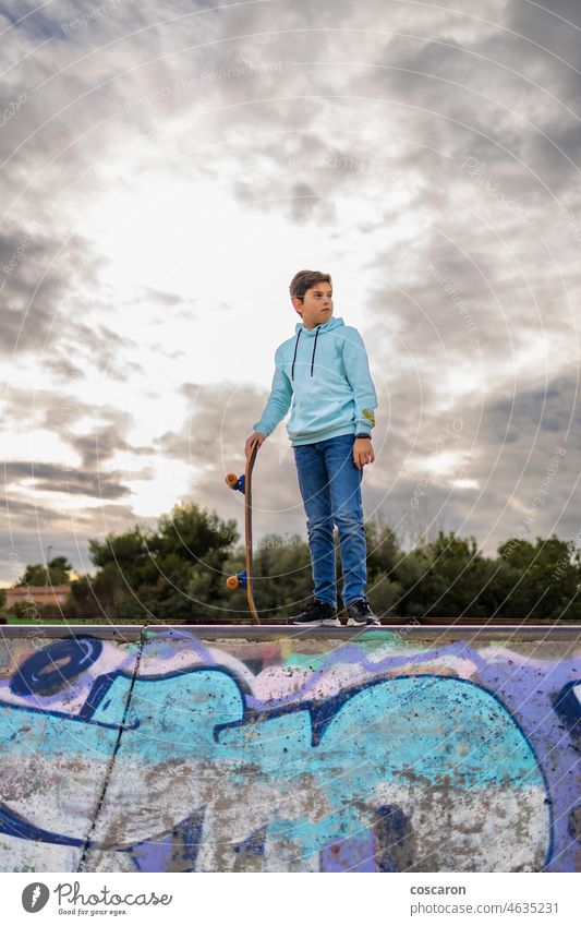 Cute teen on a skate park against a cloudy sky action activity adolescence athletic awesome board boarding boy casual caucasian child childhood city clothing