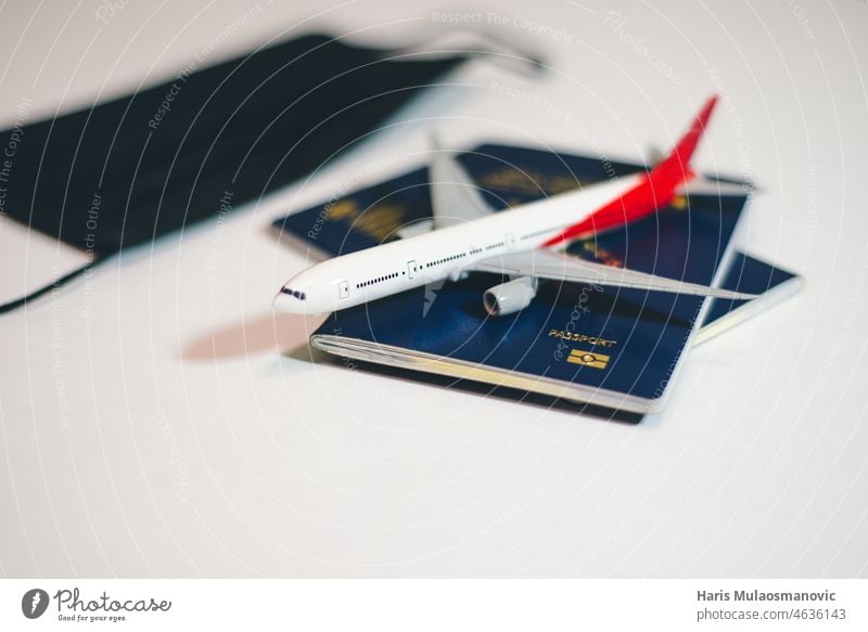 Airplane with passports and face mask on the table , covid 19 flight restrictions airplane airport aviation ban border cancelled certificate check concept