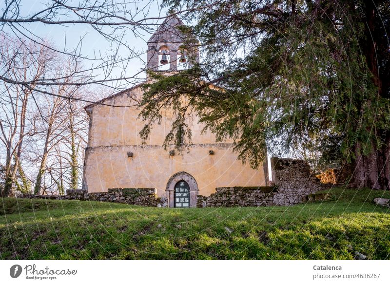 A chapel surrounded by trees Building Old Roofing tile Wall (building) Chapel Sky Plant Grass Meadow Nature firs door daylight Day Tree brick bells Church