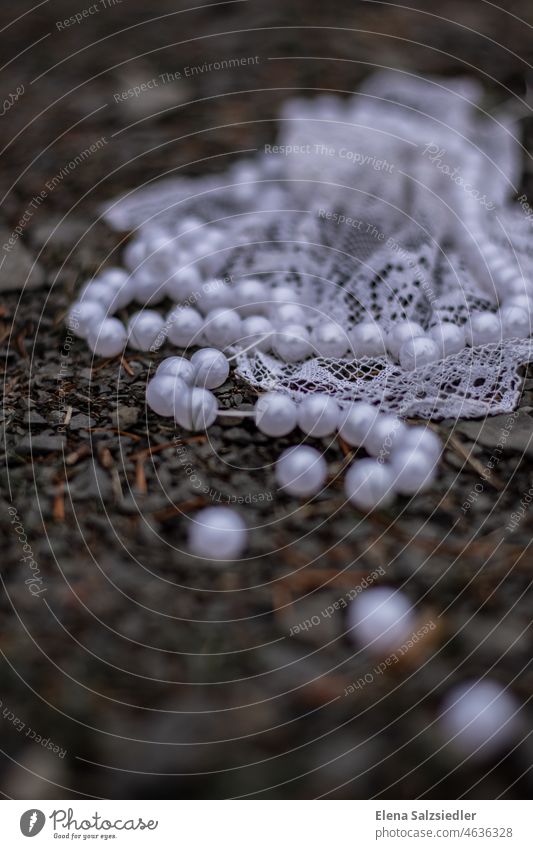 Pearl necklace and lace on the floor Trickle loose pearls Point lace towel springs bead on demolition floor blurred thread vintage Retro Broken Old