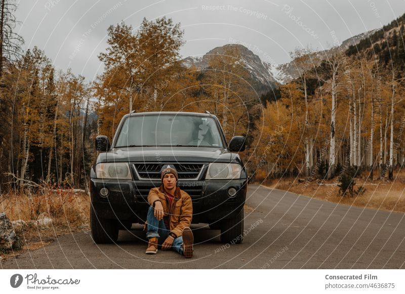 Man sitting in front of his adventure car in the mountains Adventure Travel Car Wonder Vehicle Adventure Car Jeep Mountains Mountain Vehicle Travel Vehicle