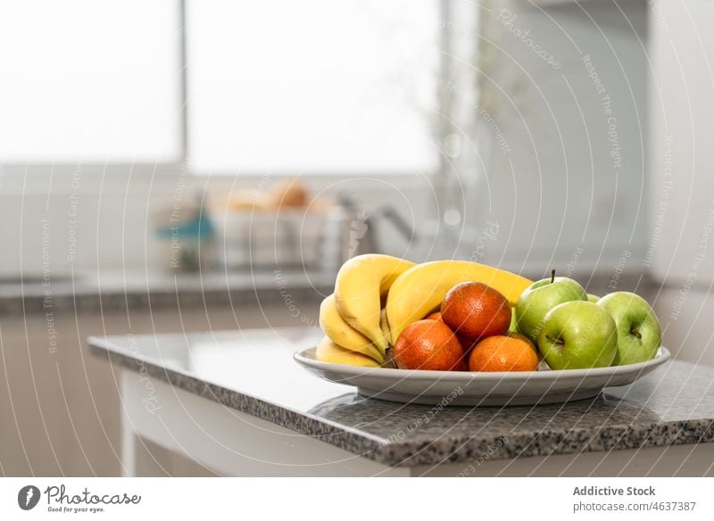 Fresh fruits on kitchen counter vitamin assorted banana apple healthy food orange apartment domestic flat at home residential light cabinet detail ripe tasty