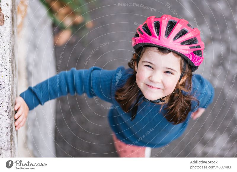 Cute girl in helmet near border kid road hobby smile childhood street leisure spend time happy activity barrier practice summer path recreation casual cheerful