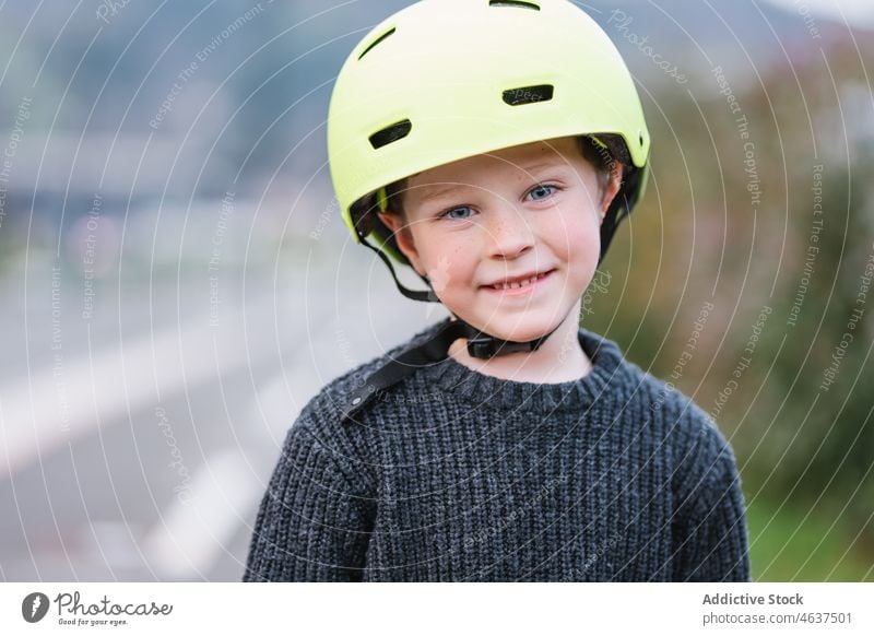 Content boy in protective helmet kid hobby childhood street leisure activity ride skate safety summer active delight recreation asphalt casual happy amusement