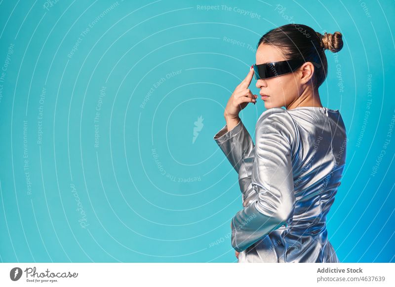 Ethnic woman touching face while experiencing virtual reality in futuristic glasses touch face style simulate augmented portrait trendy experience digital vr