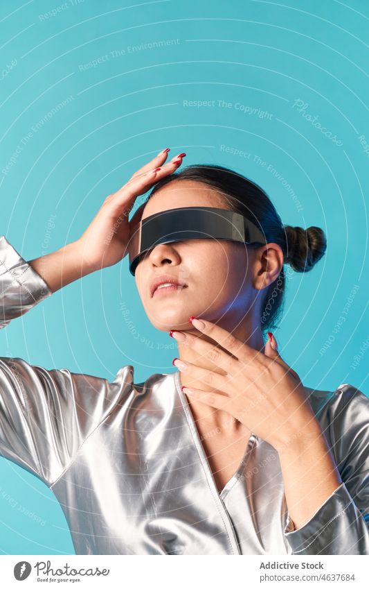 Ethnic woman touching face while experiencing virtual reality in futuristic glasses touch face style simulate augmented portrait trendy experience digital vr