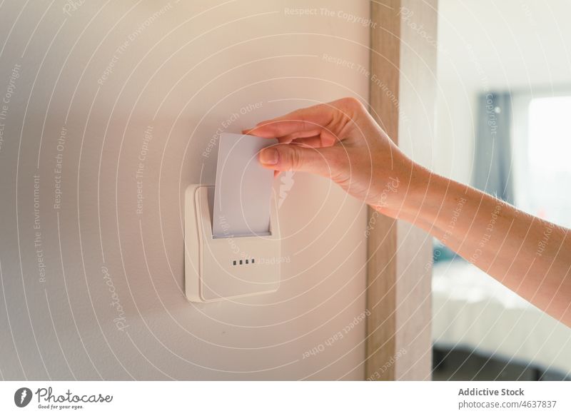 Crop lady inserting card key into switch in hotel room woman holiday travel accommodation open safety modern trip female hand access apartment style design