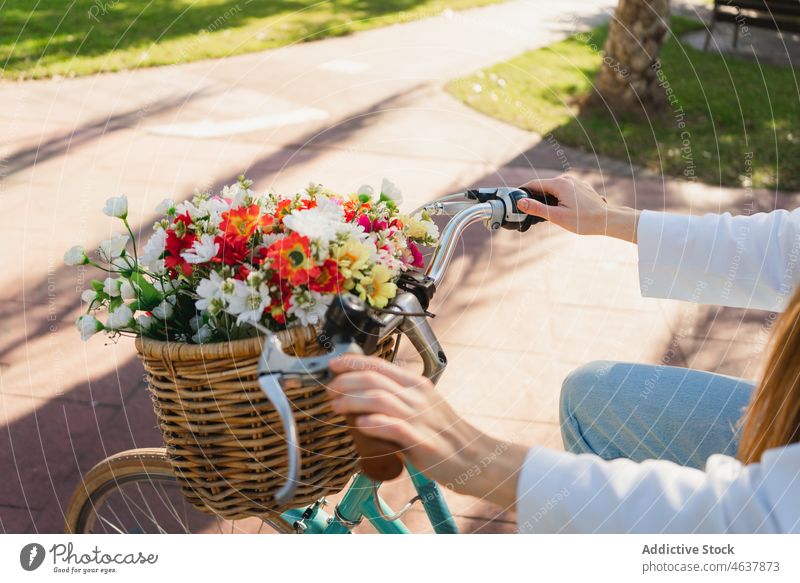 Anonymous woman with a bicycle in park ride path flower weekend tropical style summer female casual bouquet young exotic fresh blossom alley way vehicle trendy