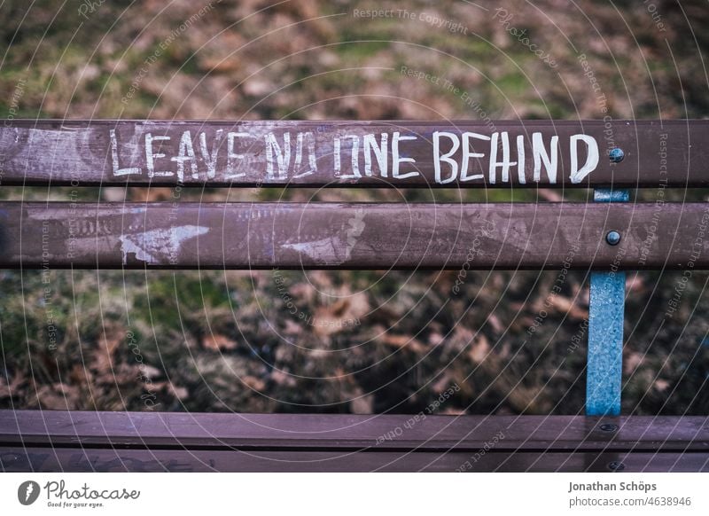 Leave no one behind - writing on park bench social equity Fairness leave no one behind refugees welcome Day Welcome Refugee Tolerant Cosmopolitanism