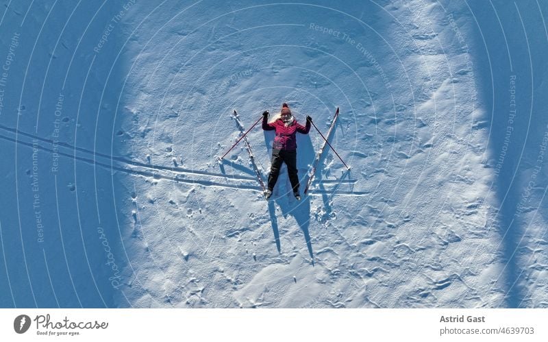 Luftaufnahme mit einer Drohne von einer Frau mit Langlaufski im Schnee. Wintersport für Senioren luftaufnahme drohnenfoto frau seniorin winter schnee
