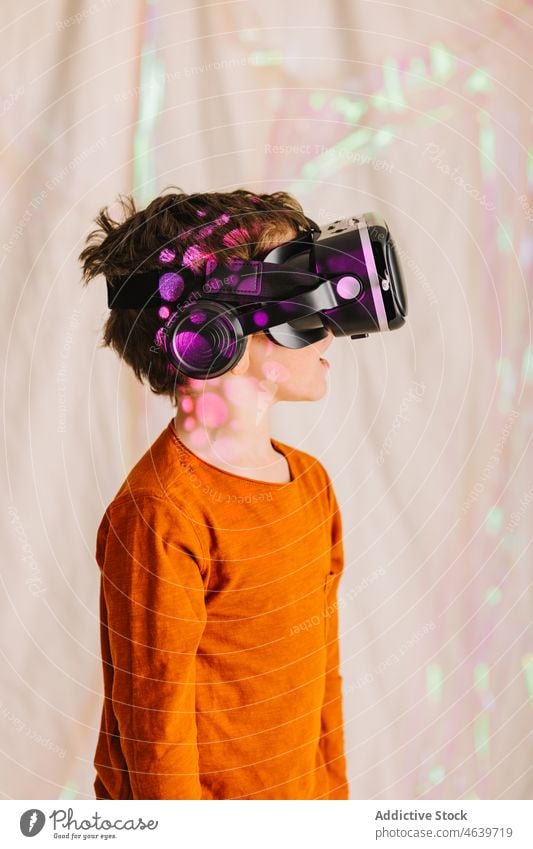 Boy exploring cyberspace in VR glasses child virtual reality explore boy experience vr goggles kid headset neon gadget device innovation digital futuristic