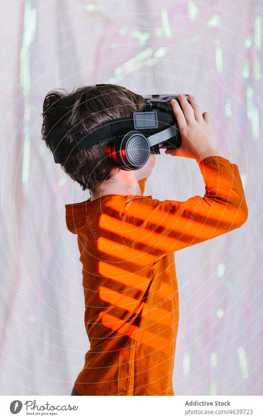 Boy exploring cyberspace in VR glasses child virtual reality explore boy experience vr goggles kid headset neon gadget device innovation digital futuristic