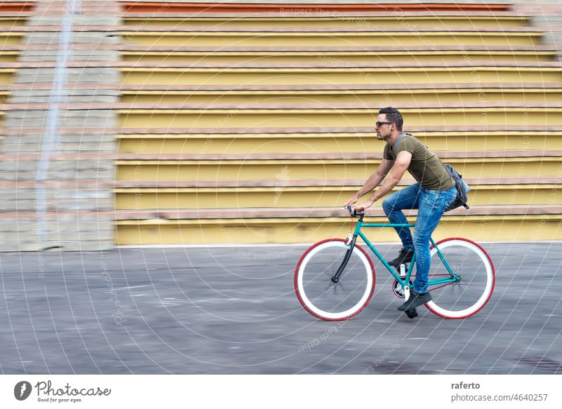Man with sunglasses riding bicycle in urban city commuting trendy transportation fixie fixed gear man biking lifestyle person street young outdoor male hipster