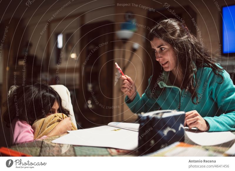 A mother scolds her daughter while doing homework at home children chores domestic realistic tracksuit books student activity people caucasian spanish lifestyle