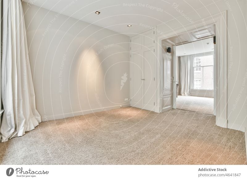 Empty room with white walls and ceiling interior door fireplace unfurnished windows carpet floor empty design entrance apartment doorway style corner entry exit