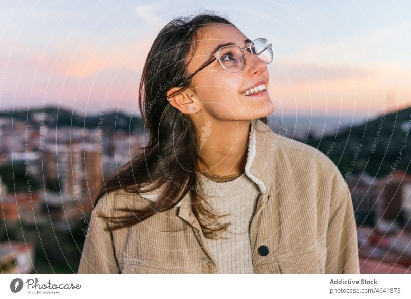 Delighted woman in eyeglasses at sunset teen carefree happy charming sundown personality portrait glee delight female glad individuality toothy smile content